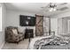 This bedroom boasts a ceiling fan, large tv, barn door to bath and chair for relaxing at 34990 N Spur Cir, San Tan Valley, AZ 85144
