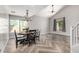 Bright dining area featuring a ceiling fan, stylish lighting, and herringbone wood-look tile flooring at 34990 N Spur Cir, San Tan Valley, AZ 85144