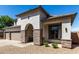 Charming stucco home featuring a stone pillar archway, neutral colors, and a three-car garage at 34990 N Spur Cir, San Tan Valley, AZ 85144