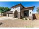 Charming stucco home featuring a stone pillar archway, neutral colors, and a three-car garage at 34990 N Spur Cir, San Tan Valley, AZ 85144