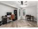 Well-lit home office with herringbone floors, ceiling fan, and dual workstations for productivity at 34990 N Spur Cir, San Tan Valley, AZ 85144