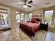 Bedroom with a red patterned bedspread, ceiling fan, and view of the outdoor living space at 4203 E Narrowleaf Dr, Gilbert, AZ 85298