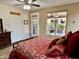 Bedroom with neutral walls, red bedspread, and view of the outdoor living space at 4203 E Narrowleaf Dr, Gilbert, AZ 85298