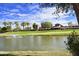 Scenic view of a pond on a golf course with lush green grass, palm trees, and a fountain spraying water at 4203 E Narrowleaf Dr, Gilbert, AZ 85298