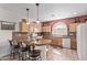 Inviting kitchen featuring a breakfast bar with seating, wood cabinetry, and a charming arched window over the sink at 4203 E Narrowleaf Dr, Gilbert, AZ 85298