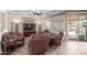 Cozy living room with tile flooring, plantation shutters, ceiling fan, and comfortable leather furniture at 4203 E Narrowleaf Dr, Gilbert, AZ 85298