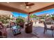 Relaxing covered patio with comfortable seating, ceiling fan, and views of the landscaped backyard at 4203 E Narrowleaf Dr, Gilbert, AZ 85298