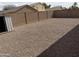 Fully fenced backyard with gravel throughout and a shed in the corner at 43818 W Arizona Ave, Maricopa, AZ 85138