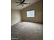 This bedroom has a ceiling fan, neutral walls and carpet, and a window letting in lots of natural light at 43818 W Arizona Ave, Maricopa, AZ 85138