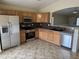 Well-lit kitchen with stainless steel appliances, granite countertops and wood cabinets at 43818 W Arizona Ave, Maricopa, AZ 85138