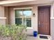 Inviting front porch with a window and a brown front door at 45717 W Ranch Rd, Maricopa, AZ 85139