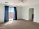 Spacious living room with a sliding door, neutral carpet, and neutral wall paint at 45717 W Ranch Rd, Maricopa, AZ 85139