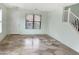 Bright living room with tile floors, staircase, and a white front door at 45717 W Ranch Rd, Maricopa, AZ 85139