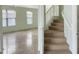 Staircase with neutral carpet and white railing adjacent to bright, windowed living area at 45717 W Ranch Rd, Maricopa, AZ 85139