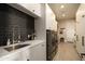 Functional laundry room with gray subway tile, white cabinetry, and modern washer/dryer at 6455 E Calle Del Media --, Scottsdale, AZ 85251