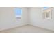 Bright bedroom with white walls, carpeted flooring, and two windows at 7436 W Buckhorn Trl, Peoria, AZ 85383