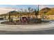 Landscaped Aloravita community entrance with native plants and stone accents against mountain views at 7436 W Buckhorn Trl, Peoria, AZ 85383