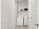 Bright laundry room featuring a washer, dryer, storage shelf, and neutral tones at 7436 W Buckhorn Trl, Peoria, AZ 85383