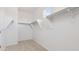 Empty walk-in closet with carpeted flooring, white walls, shelving, and a small window at 7436 W Buckhorn Trl, Peoria, AZ 85383