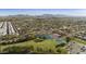 Wide aerial shot showcasing a well-planned community with a golf course, lake, and picturesque mountain backdrop at 755 S Arrowwood Way, Mesa, AZ 85208