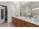 Well-lit bathroom featuring a double sink vanity and a mirror, with a walk-in closet and separate shower area at 927 E Baylor Ln, Gilbert, AZ 85296