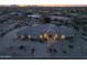 Stunning aerial view of the property showcasing its tile roof, arched windows, private drive, and desert landscaping at dusk at 9826 N 131St St, Scottsdale, AZ 85259