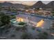 Majestic home with a luxurious pool and outdoor living area, set against a stunning mountain backdrop at twilight at 9826 N 131St St, Scottsdale, AZ 85259