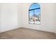 Bright bedroom with light wood floors and a large arched window offering beautiful views of the neighborhood at 9826 N 131St St, Scottsdale, AZ 85259