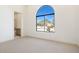 Bright bedroom with an arched window offering a view of the neighborhood at 9826 N 131St St, Scottsdale, AZ 85259