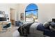 Bedroom with desk and computer, plus a large arched window showing neighborhood view at 9826 N 131St St, Scottsdale, AZ 85259