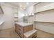 Spacious walk-in closet with custom shelving, an island with marble countertop, and modern lighting at 9826 N 131St St, Scottsdale, AZ 85259