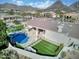 Backyard view featuring a covered patio, built-in BBQ, pool with waterfall feature, and lush landscaping at 9826 N 131St St, Scottsdale, AZ 85259