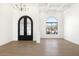 Bright foyer featuring arched double doors, wood floors, coffered ceiling, and large arched window at 9826 N 131St St, Scottsdale, AZ 85259