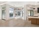 Bright living room with wood floors, open windows, breakfast bar, and kitchen in background at 9826 N 131St St, Scottsdale, AZ 85259