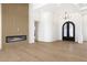 Open-concept room with fireplace, hardwood floors, high ceilings, and an archway with black double doors at 9826 N 131St St, Scottsdale, AZ 85259