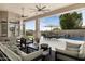 Covered patio featuring ceiling fans, comfortable seating, and an outdoor dining area overlooking the pool at 9826 N 131St St, Scottsdale, AZ 85259