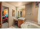 Bathroom features an adjacent vanity and soaking tub with tiled floor at 10325 E Celestial Dr, Scottsdale, AZ 85262