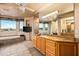 Bathroom featuring double sinks, a large vanity and soaking tub with desert views at 10325 E Celestial Dr, Scottsdale, AZ 85262