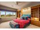 Bright bedroom featuring scenic golf course view and custom built-ins at 10325 E Celestial Dr, Scottsdale, AZ 85262