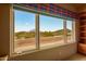 A bedroom window displays a stunning view of the golf course and desert at 10325 E Celestial Dr, Scottsdale, AZ 85262