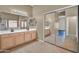 Bright bathroom featuring a double vanity, large mirror, tile floors, and a closet with mirrored sliding doors at 10816 W Palm Ln, Avondale, AZ 85392