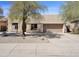 Beige single-story home with a well-maintained yard and two-car garage at 10816 W Palm Ln, Avondale, AZ 85392