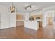 Open-concept kitchen and dining area with wooden cabinets, tile flooring, and modern lighting fixtures at 10816 W Palm Ln, Avondale, AZ 85392