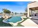 Inviting backyard pool with lush landscaping, outdoor kitchen, and scenic lake views at 10816 W Palm Ln, Avondale, AZ 85392