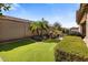 Landscaped backyard features an outdoor kitchen area, manicured lawn, mature trees, and a decorative fountain at 1163 E Holbrook St, Gilbert, AZ 85298