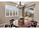 A breakfast nook features a wooden table, a chandelier, and views of the backyard through a sliding glass door at 1163 E Holbrook St, Gilbert, AZ 85298