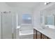 Well-lit bathroom featuring a shower, bathtub, window, and vanity with dark wood cabinets at 11669 N 165Th Ave, Surprise, AZ 85388