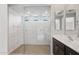 Bathroom featuring a modern shower with glass surround, tile flooring and a double sink vanity at 13512 W Copperleaf Ln, Peoria, AZ 85383