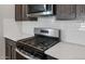 Close-up of a stainless steel gas range and microwave, complemented by white subway tile backsplash at 13512 W Copperleaf Ln, Peoria, AZ 85383