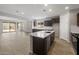 Spacious open kitchen featuring dark cabinets, stainless appliances, and a large center island at 13512 W Copperleaf Ln, Peoria, AZ 85383